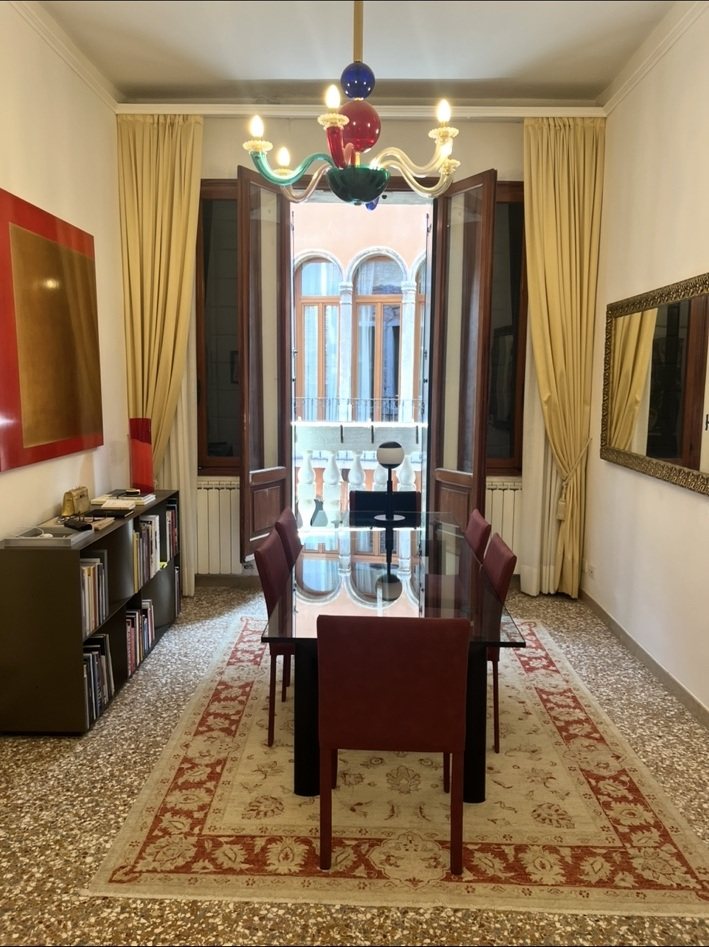 Sala dell’appartamento a Venezia, con pavimento alla veneziana e porte-finestre aperte