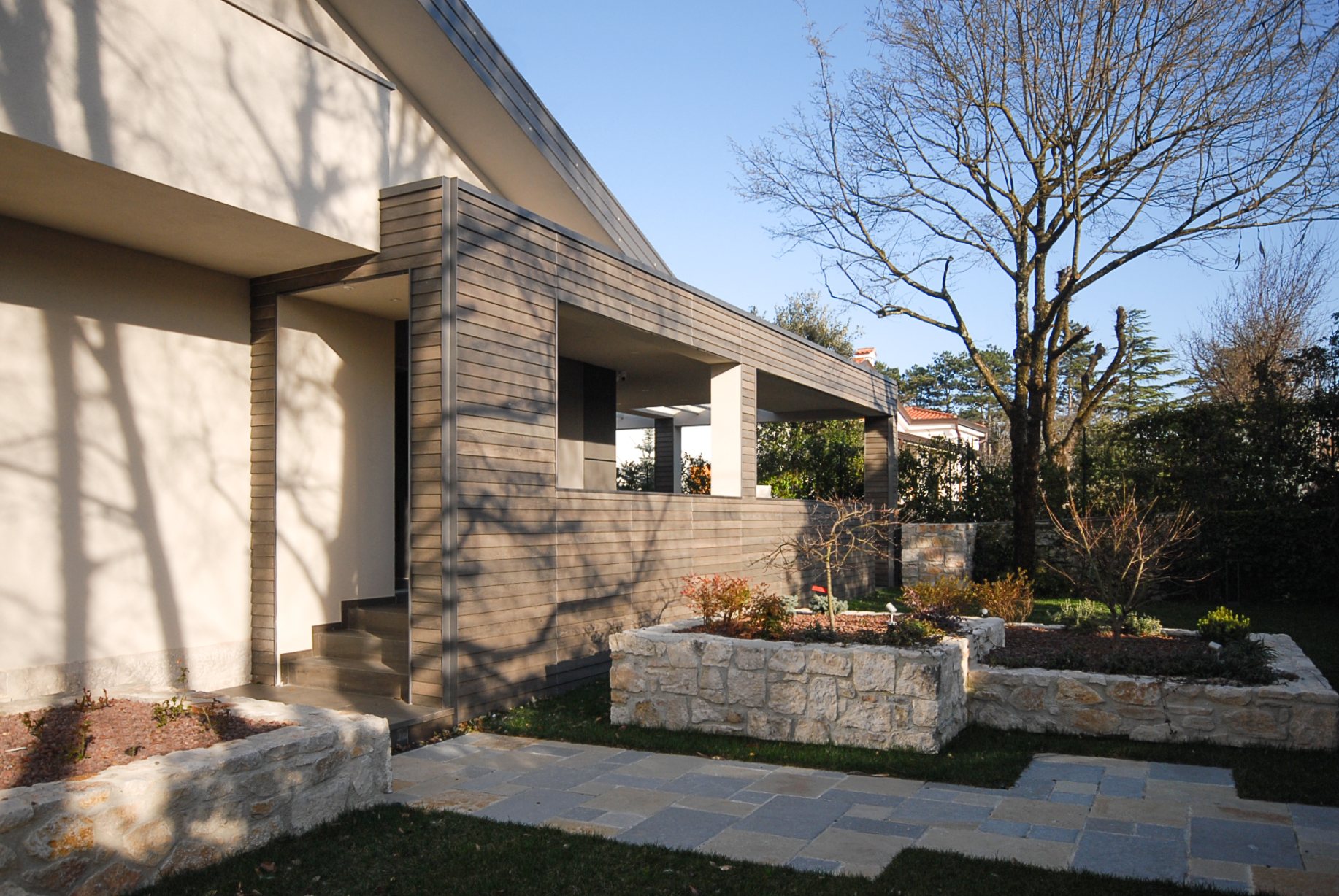 Ampliamento della villa a Opicina, facciata e giardino con rivestimento in legno